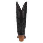 A single black leather cowboy boot shown from the back, featuring black floral debossed embroidery and a stacked brown wooden heel, set against a plain white background.